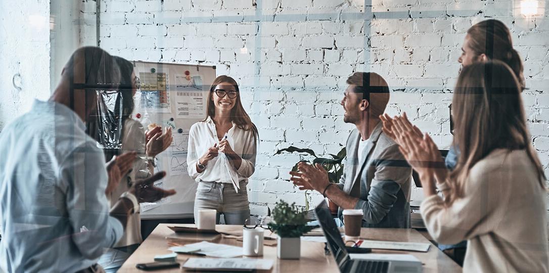 People in the office applauding a woman